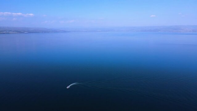 The Sea of Galilee on a pastoral sunny spring day,
A sports boat races through the calm waters.
Drone shot
The Galilee and Golan mountains in the background around the lake