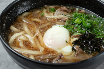 A closeup view of a bowl of beef udon soup.