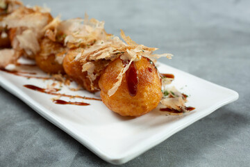 A closeup view of a plate of takoyaki.