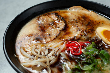 A view of a tonkatsu ramen bowl, featuring black garlic oil.