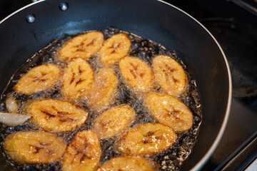 Deep frying plantain a frying pan in Kitchen