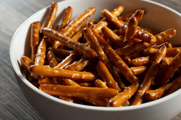 A closeup view of a bowl of gluten-free pretzel sticks.