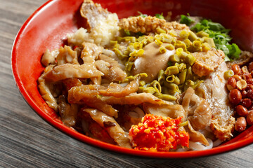 A closeup view of a bowl of pork intestines rice noodles.