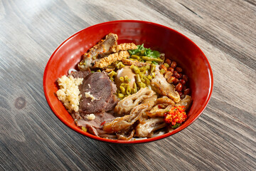 A view of a bowl of beef slices and pork intestine rice noodles.