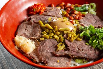 A closeup view of a bowl of beef rice noodles.