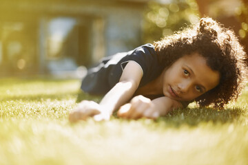 Portrait, sunshine and boy on grass, play and nature with fun, weekend break and relaxing. Face,...