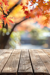A wooden desk top with blurred background of maple tree with autumn foliage. Good for background 