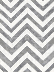 A chevron patterned wall with a grey and white color scheme. The chevron pattern is bold and striking, creating a sense of movement and energy. The gray and white color scheme gives the room a modern