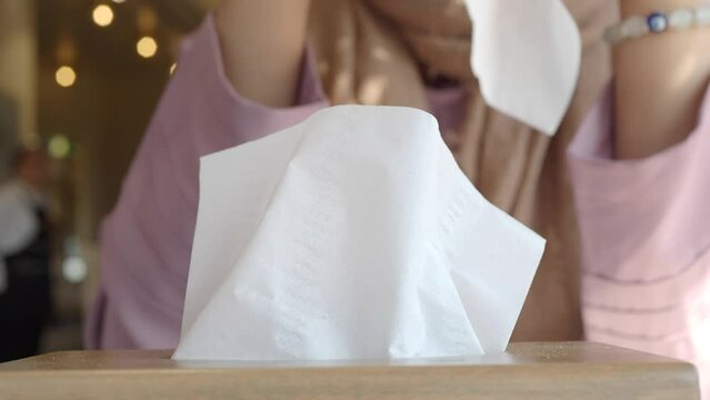  hand pull out a piece of tissue from tissue paper box 