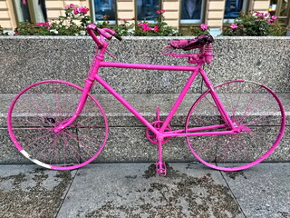 Old pink bicycle leaning on the street