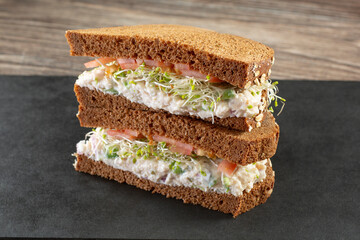 A view of a tuna salad sandwich stack on squaw-bread.