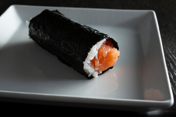 A closeup view of a hand roll, featuring lean tuna.