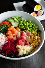 A view of a poke bowl and some hand rolls.