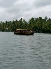 Naklejka premium Kettuvallam is a houseboat widely used in the Indian state of Kerala. These have thatched roof covers over wooden hulls. The traditional kettuvallam is mainly used for promoting Kerala tourism. 