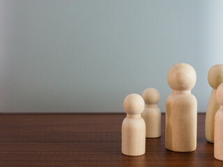Group of wooden puppets in a meeting or selection of leaders on a gray background