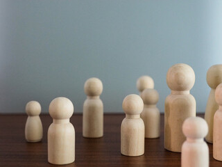 Group of wooden puppets in a meeting or selection of leaders on a gray background