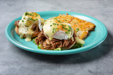 A closeup view of a plate of short ribs eggs Benedict.