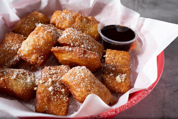A closeup view of a basket of beignets.