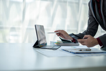 A man is sitting at a desk with a laptop and a tablet