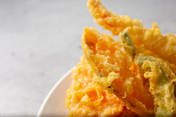 A view of a plate of assorted tempura vegetables, on the right side of the frame.