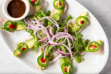 A top down view of a plate of sashimi yellowtail.