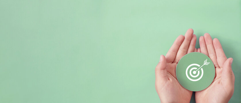 Hand holding target paper cut, achieve on point, sustainable challenge goal, business success future plan concept