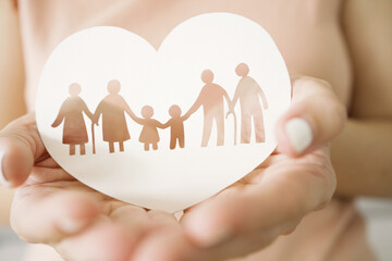 Hands holding multi generational family paper, family wellness, health insurance concept
