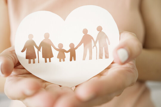 Hands holding multi generational family paper, family wellness, health insurance concept
