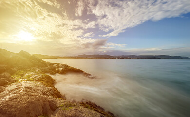 Landscape evening view ocean bay  smooth surface with sunset light effect with long exposures  and selective focus  background.