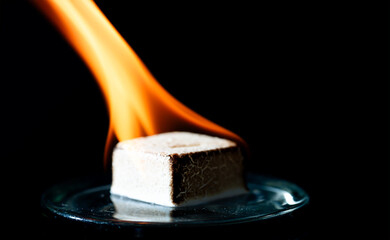 Burning match firelighter to create hot flame on black background. 