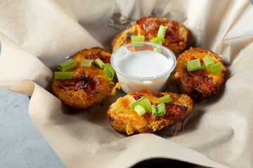 A closeup view of a basket of loaded potato skins.
