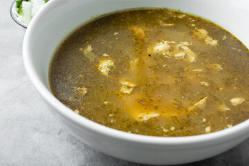 A closeup view of a bowl of pozole verde.