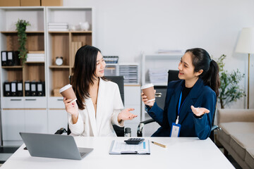 Businesswomen work and discuss their business plans. A woman employee explains and shows her colleague the results paper