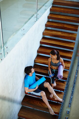 Stairs, rest and man with woman for fitness, calm workout, yoga class and share health advice. Friends, exercise break and couple by steps for wellness and gossip conversation after training together