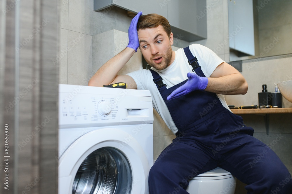 Wall mural Technician repairing a washing machine