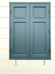 Closed wooden window on a white building wall