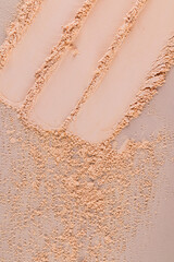 abstract cosmetic background. Three swatches of compact powder in a natural tone and loose powder on a beige background. The upper vertical view
