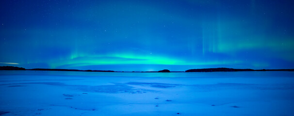 Northern lights dancing over frozen lake in Farnebofjarden national park in north of Sweden