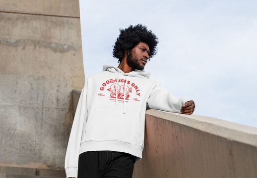 Mockup of man wearing customized hoodie leaning on wall