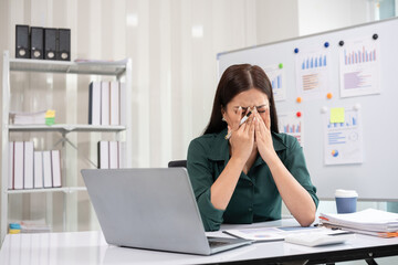 Young businesswoman has problems with her work in the office Feeling stressed and unhappy, showing...