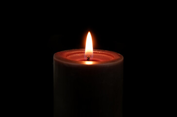 Black candle burning and melting on black background close-up. Copy space for text.