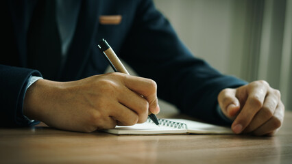 businessman working at work table,home office desk background, checklist writing planning...