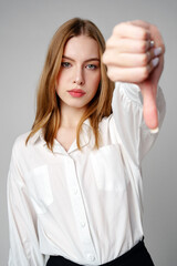 Young Woman in White Shirt Pointing Finger Down Dislike