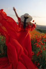 Woman poppy field red dress hat. Happy woman in a long red dress in a beautiful large poppy field....