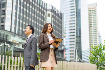 Portrait of Asian businessman and businesswoman working corporate business with digital device in...