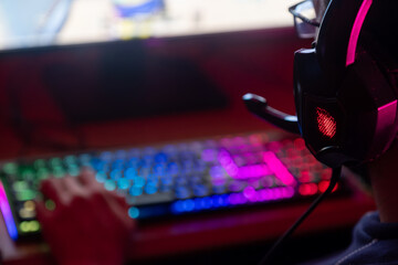 Gamer deeply engaged in a game, surrounded by colorful lights and high-tech equipment.