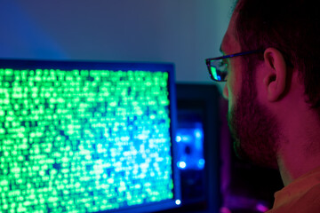 A person analyzing code on a screen, engaged in hacking activities