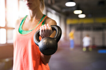 Beautiful sport woman exercising with kettlebell. Routine workout for woman's physical and mental...
