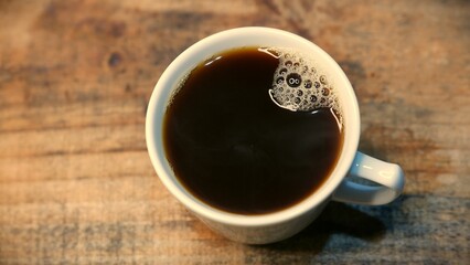 A close-up shot of a cup of hot coffee on the table. An espresso coffee cup ready to drink. An...