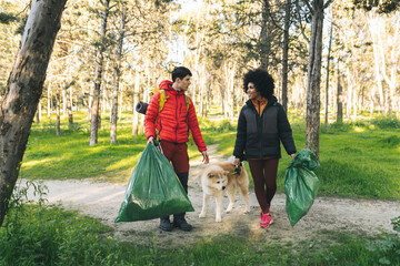 Couple Picking Up Litter with Dog in Forest
